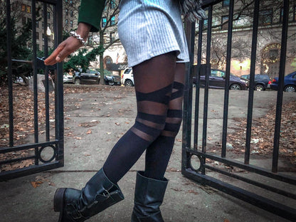 Women's black sheer and opaque patterned tights featuring a modern graphic V-strap style design.