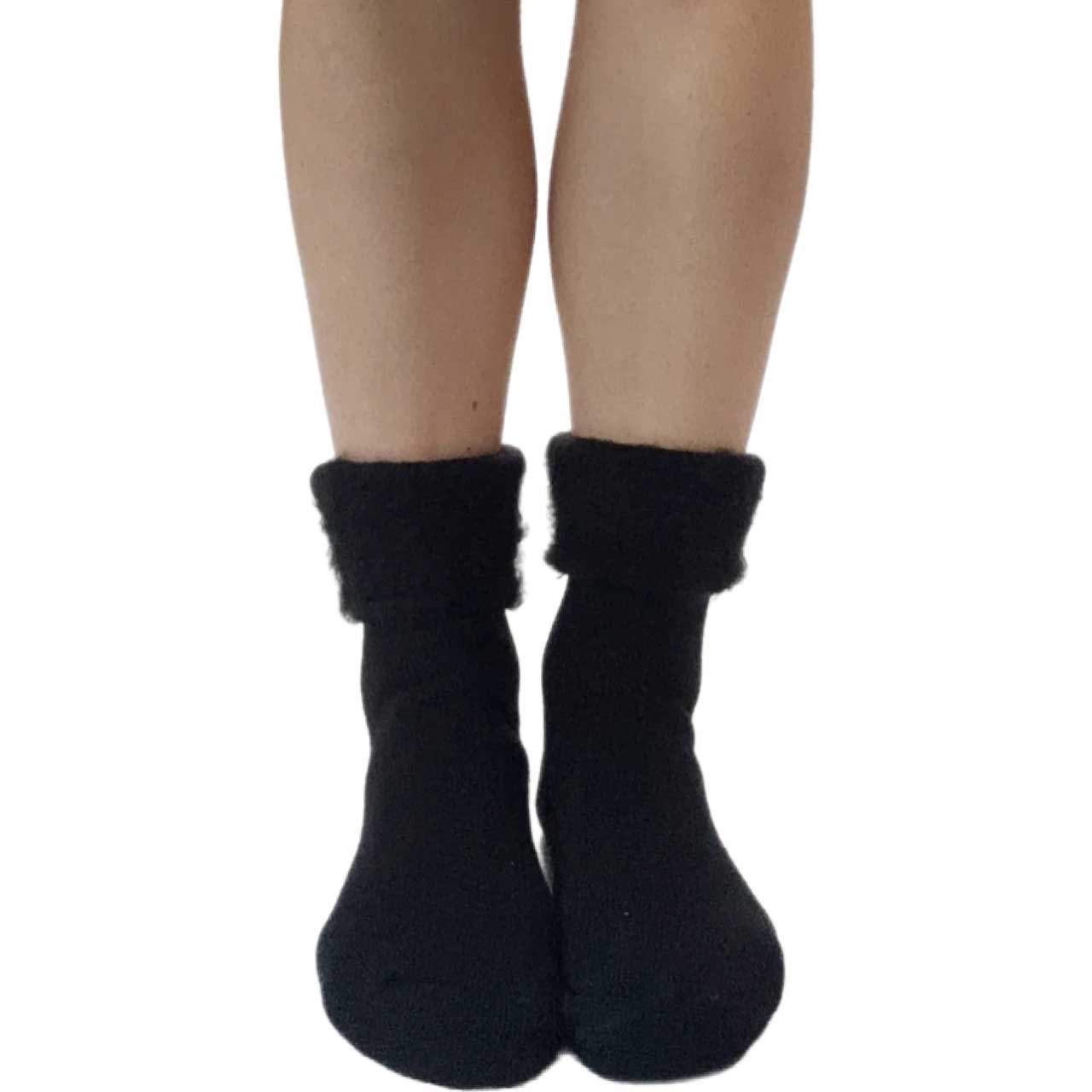 Woman wearing black extra wide thermal socks with ultra-soft plush cuff and cozy winter design.