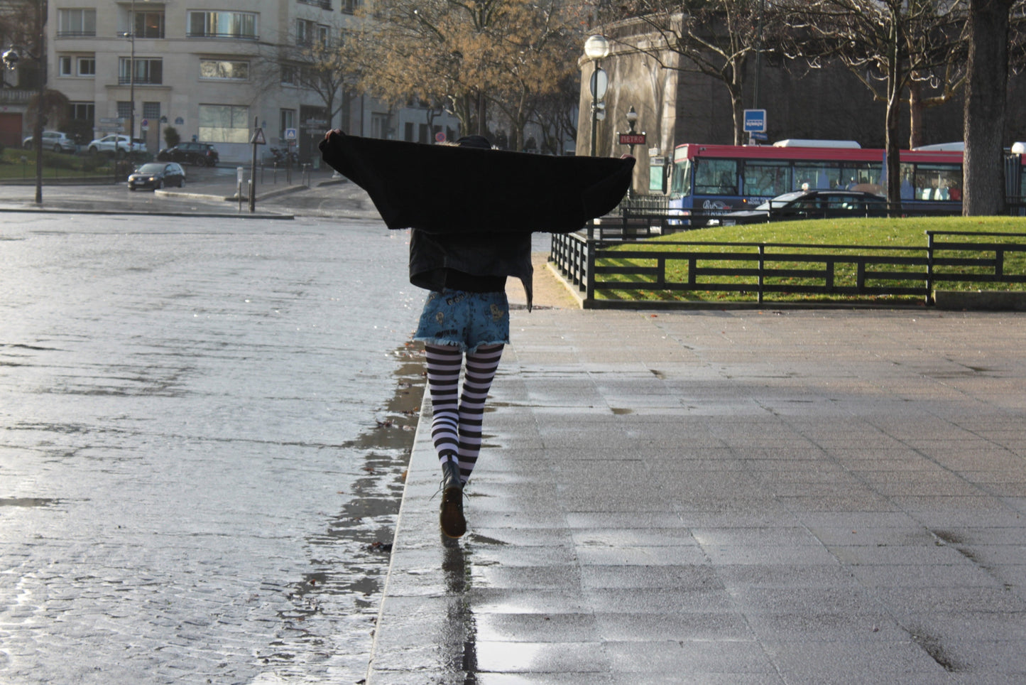 Women walking in Paris with a black coat and striped tights sold at Malka Chic