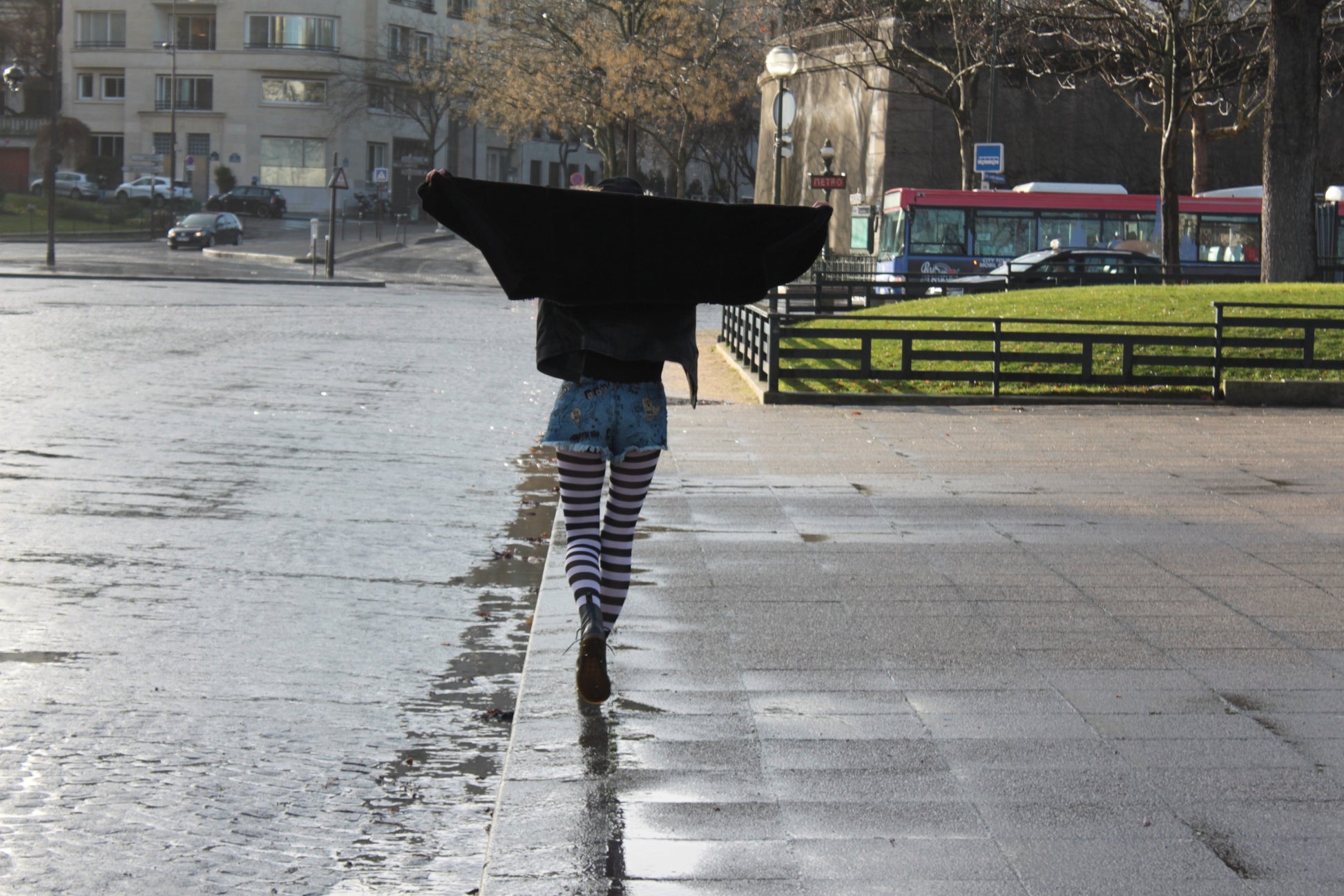Women walking in Paris with a black coat and striped tights sold at Malka Chic