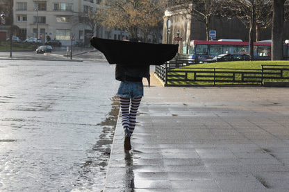 Women walking in Paris with a black coat and striped tights sold at Malka Chic