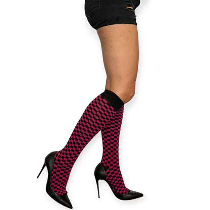 Women’s knee-high checkerboard socks by Malka Chic with alternating fuchsia and black squares.