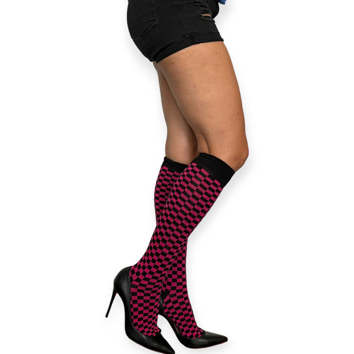 Fuchsia and black checkerboard knee-high socks for women by Malka Chic styled with black shorts and pointed heels.