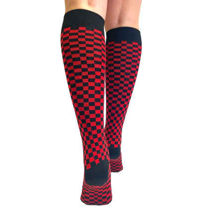 Women's red and black checkered knee-high socks with a warped checkerboard design, soft knit fabric, and alternative fashion style.