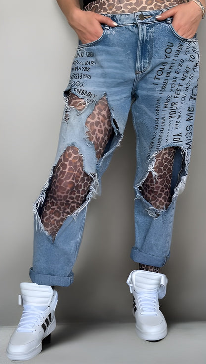 Person wearing distressed blue jeans with leopard print patches sold at Malka Chic