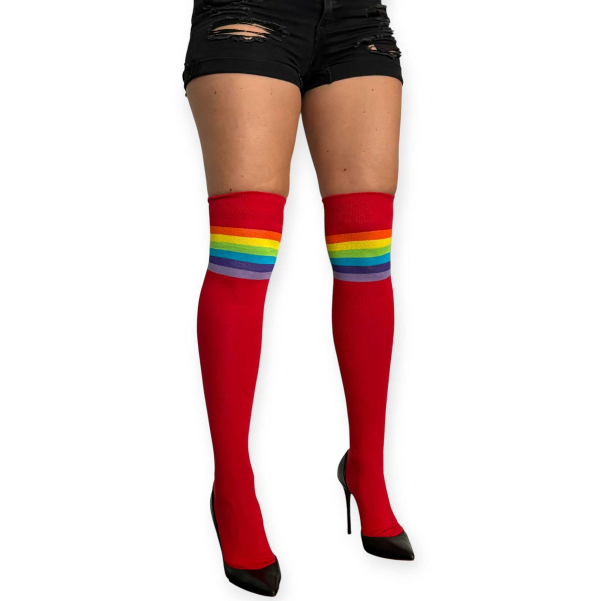 Red rainbow over the knee socks for women by Malka Chic with multicolor stripes, styled with black shorts and pointed heels.