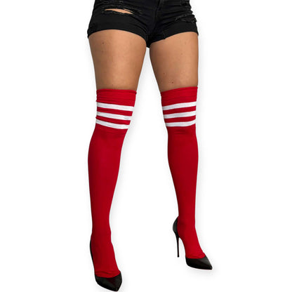 Red over the knee socks for women by Malka Chic with three white stripes at the top, styled with black shorts and heels.