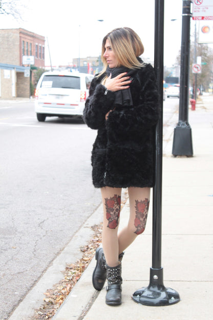 Woman in a black fur coat wearing a Skull and Roses Sheer Tattoo Tights For women sold at Malka Chic